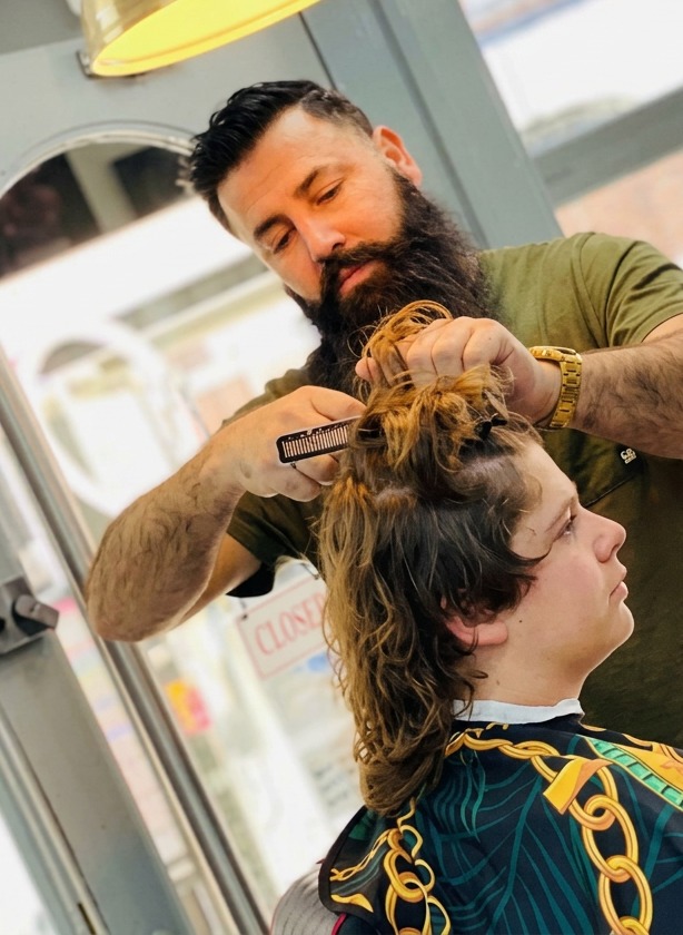Barber giving a precision haircut at MO BARBER